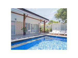 龍目島的住宿－海古那亞維拉旅館，一座房子后院的游泳池