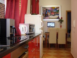 a kitchen with a white refrigerator and a table with chairs at Split Artistic Apartments in Split