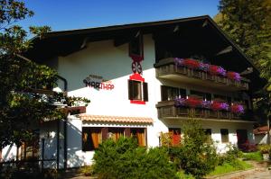 a white building with balconies and flowers on it at Pension Martha in Postal