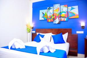 a bedroom with two beds with blue walls at Mama Beach Villa in Negombo