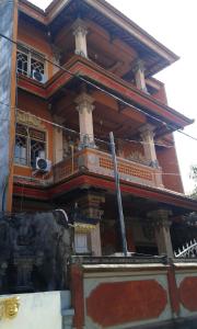 un edificio con un balcón en el lateral. en Ratih Bali Hostel en Denpasar