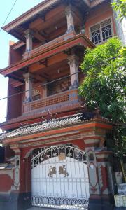 a building with a balcony on top of it at Ratih Bali Hostel in Denpasar