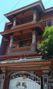 a building with a balcony on top of it at Ratih Bali Hostel in Denpasar