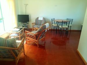 a living room with chairs and a table and a television at Wenton Farm Holiday Cottages in Middleton