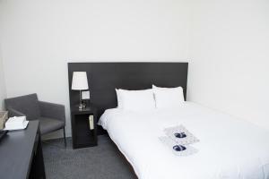 una habitación de hotel con una gran cama blanca y una silla en Best Western Yokohama en Yokohama