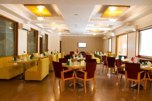 a restaurant with tables and chairs in a room at 7 Apple Hotel Pimpri Pune in Pune