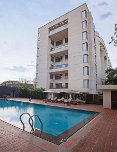 a hotel with a swimming pool in front of a building at Oakwood Residence Naylor Road Pune in Pune