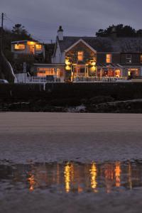 a house sitting on the beach at night at Sea View Guest House in Benllech