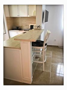 a kitchen with a counter and a table with a chair at Red House Family Hotel in Ravda