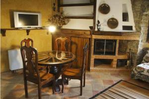 sala de estar con mesa, sillas y chimenea en Apartamentos Rurales Rincón de Aiara en Menagaray