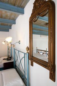 a mirror hanging on a wall next to a bed at Suites Pandora in Chania Town