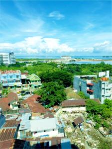 an aerial view of a city with buildings and the ocean at Travellers Hotel Phinisi in Makassar
