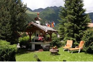 un jardín con 2 sillas y un cenador en Residence Grünwald, en Valles