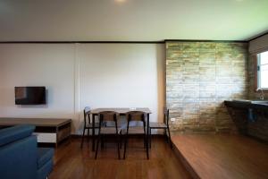 a living room with a table and chairs and a tv at Viking Resorts in Pattaya