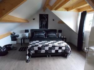 een slaapkamer met een zwart-wit bed op een zolder bij Bij Noetsele in Nijverdal