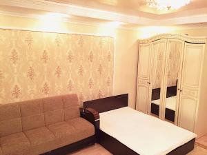 - un salon avec un canapé et une armoire dans l'établissement Vremena Goda Apartment in Astana, à Astana