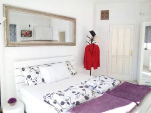 a bedroom with a white bed and a mirror at Apartments Jadran in Herceg-Novi