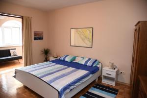una camera con letto e lenzuola bianche e blu di Downtown apartment Korina Zadar a Zara (Zadar)