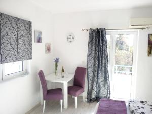 a dining room with a table and two chairs and a window at Apartments Jadran in Herceg-Novi
