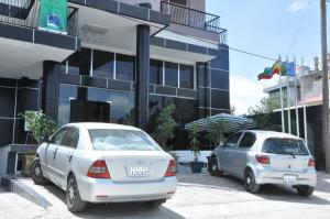 two cars parked in front of a building at Kersay Hotel in Addis Ababa