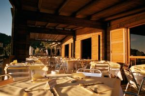 an outdoor restaurant with white tables and chairs at Hotel & Resort Sant'Anna Del Volterraio in Portoferraio