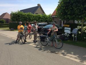 a group of people riding bikes down a street at B&B Greenhouse 37 in Langemark