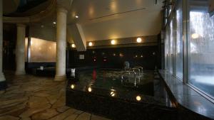 een grote badkamer met een bad in een gebouw bij The Bed and Spa (male only) in Tokorozawa