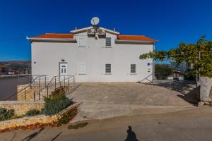 un hombre parado frente a un gran edificio blanco en Apartments Bellevue, en Trogir