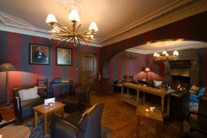 a living room filled with furniture and a fireplace at Hotel Le Beau Séjour in Nassogne