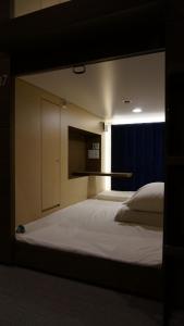 um quarto com uma grande cama branca e uma janela em The Bed and Spa (male only) em Tokorozawa