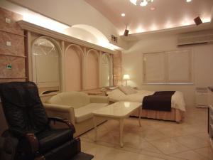 a living room with a bed and a couch at Hotel Hyper Noah (Adult Only) in Sakai
