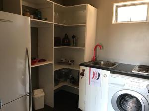 uma cozinha com uma máquina de lavar roupa e um lavatório em Miranda Sea View Apartment em Miranda