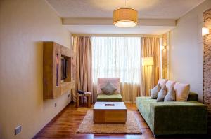 a living room with a green couch and a tv at Reata Apartment Hotel in Nairobi