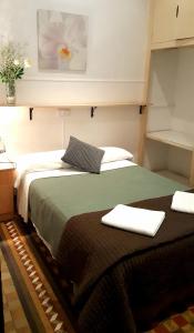 1 dormitorio con 2 camas y toallas. en Hostal Lima en Barcelona