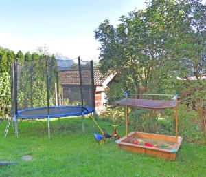 2 camas elásticas en un patio con parque infantil en Sendlerhof, en Wenns