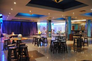 un restaurante con mesas y taburetes en una habitación en Mercury Hotel-Premium All Inclusive, en Sunny Beach