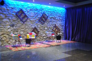 a stage with three chairs and a stone wall at Mercury Hotel-Premium All Inclusive in Sunny Beach