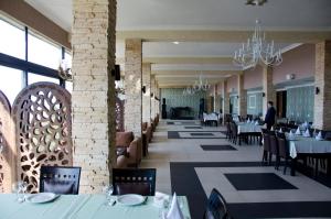 a dining room with tables and chairs and chandeliers at Sputnik Hotel Batumi in Batumi