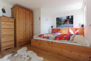1 dormitorio con cama de madera y tocador de madera en Glühwürmchenhütte, en Ratten