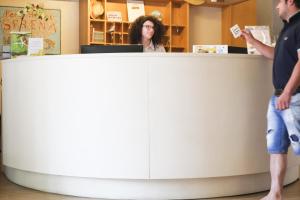 twee mensen staan aan een toonbank in een winkel bij Park Hotel Serena in Rimini