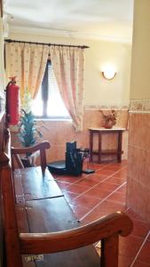 Zimmer mit einer Bank, einem Tisch und einem Fenster in der Unterkunft Aqui Jardim in Reguengos de Monsaraz