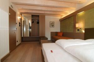 a hotel room with two beds and a couch at Dolomiti Lodge Villa Gaia in Venas