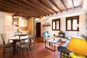 a living room with a table and a couch and a kitchen at Apartamento Puerta Elvira Centro in Granada