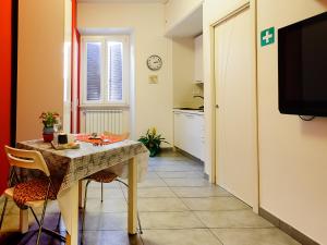 a kitchen with a table with chairs and a television at Adriatic Room I in Ciampino