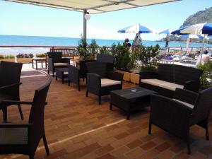 un patio con sillas y mesas y vistas al océano en Hotel Acquasanta, en Terracina