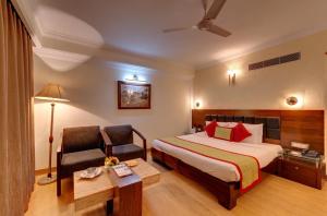 a hotel room with a bed and a chair at Hotel Combermere in Shimla