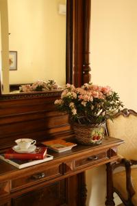 a table with a mirror and a basket of flowers on it at B&B Luna Caprese in Naples