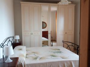 Un dormitorio con una cama con una manta blanca. en Casa dei Nonni en Vasto