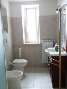 a bathroom with a toilet and a sink and a window at Casa dei Nonni in Vasto