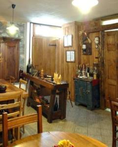 a kitchen with wooden walls and a table and chairs at Le Village in Montjovet